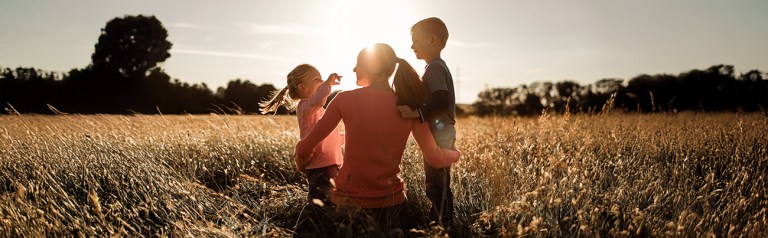 Mother engaging with two children in a beautiful flower field.